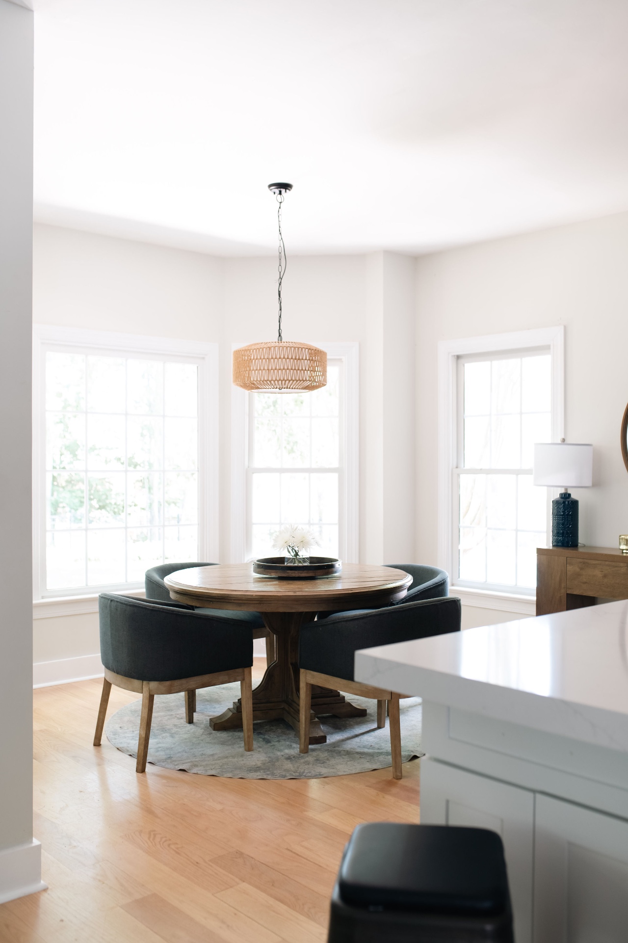 Open breakfast area off the kitchen with bay windows and casual round dining set.