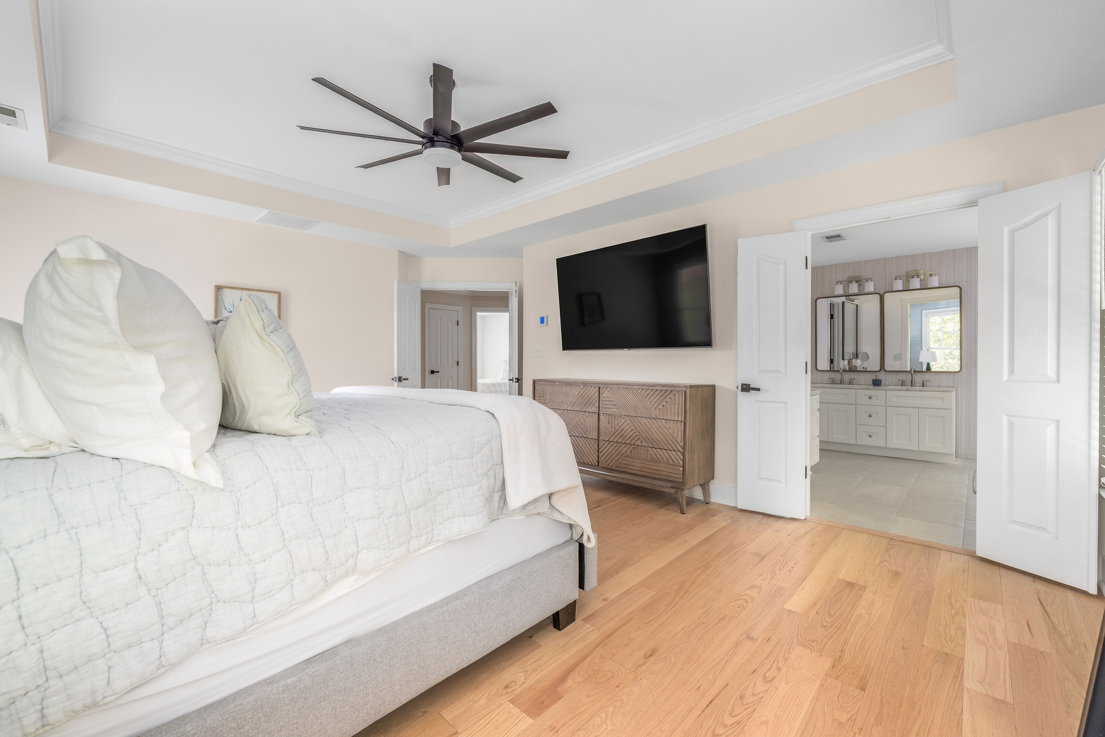 Spacious primary bedroom with elegant tray ceiling.