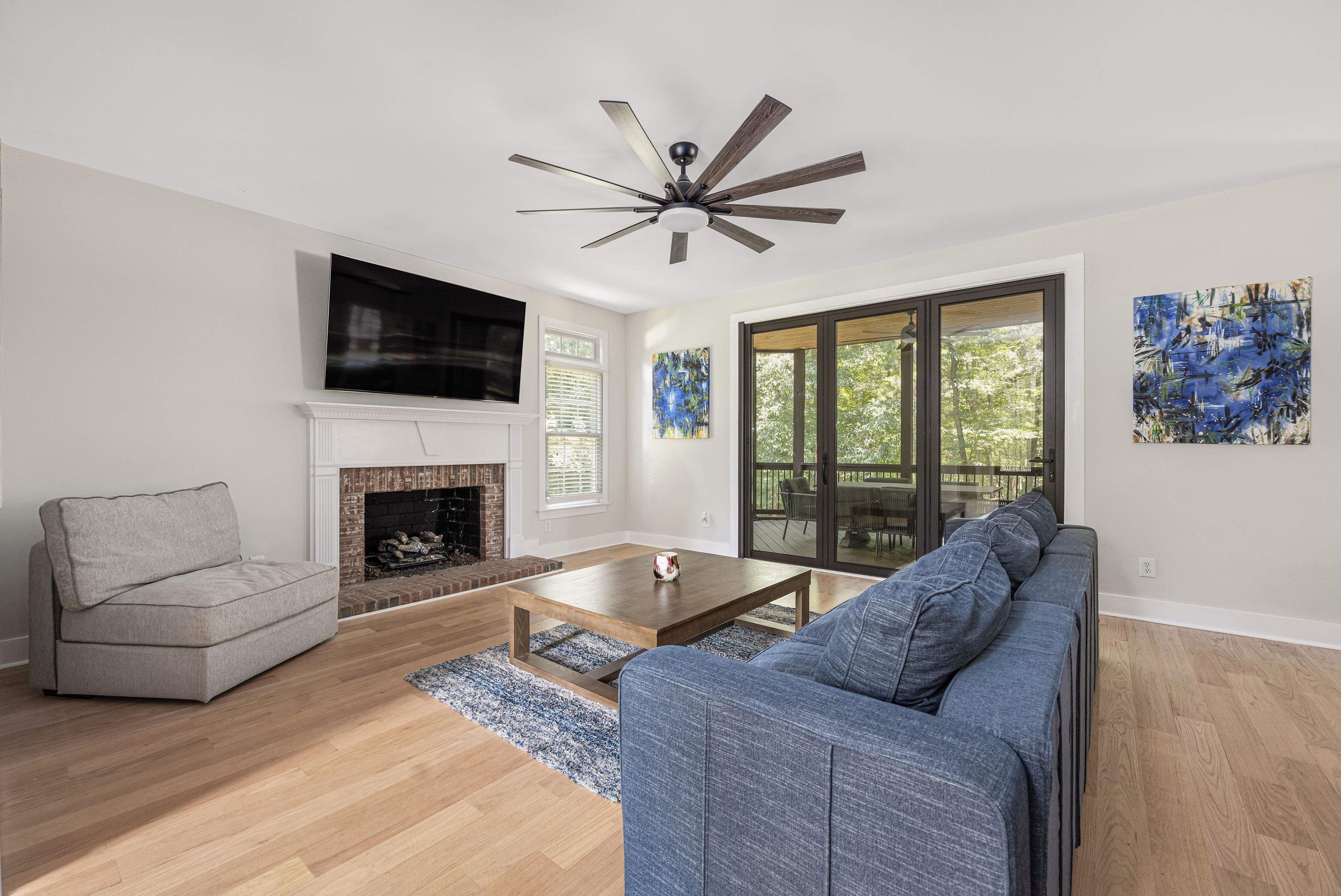 Living room with bifold doors opening to the kitchen, featuring a fireplace and an elegant archway from the entry