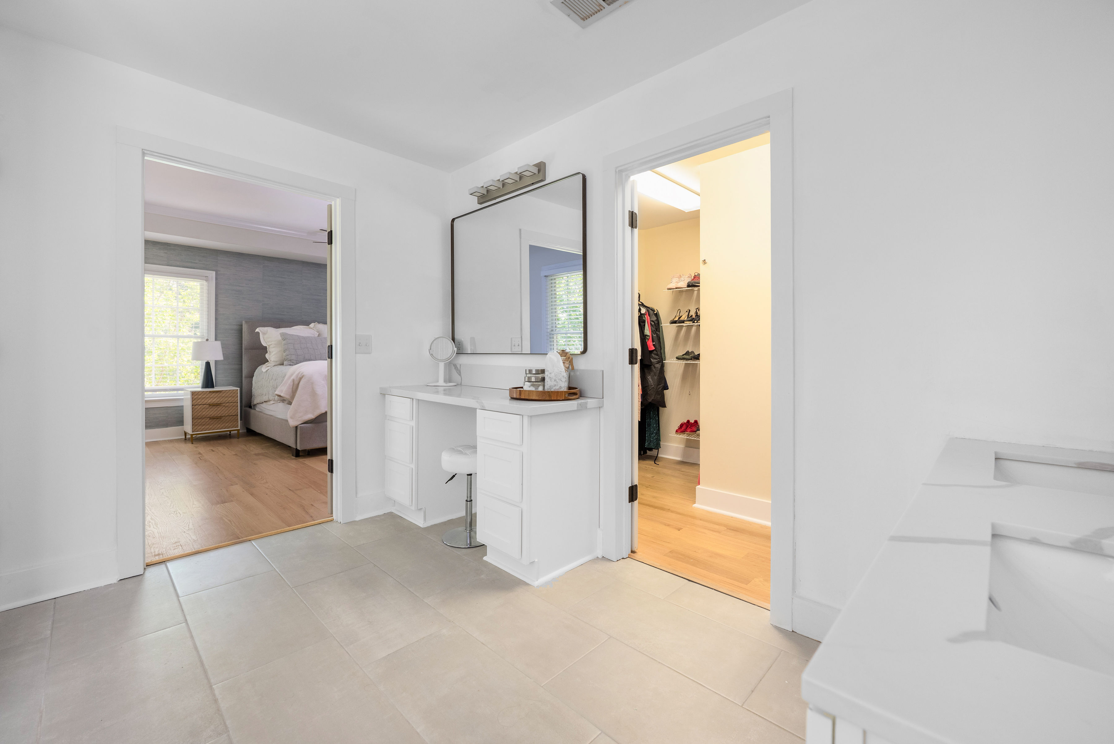 Primary bath featuring a double vanity, makeup vanity, and walk-in shower
