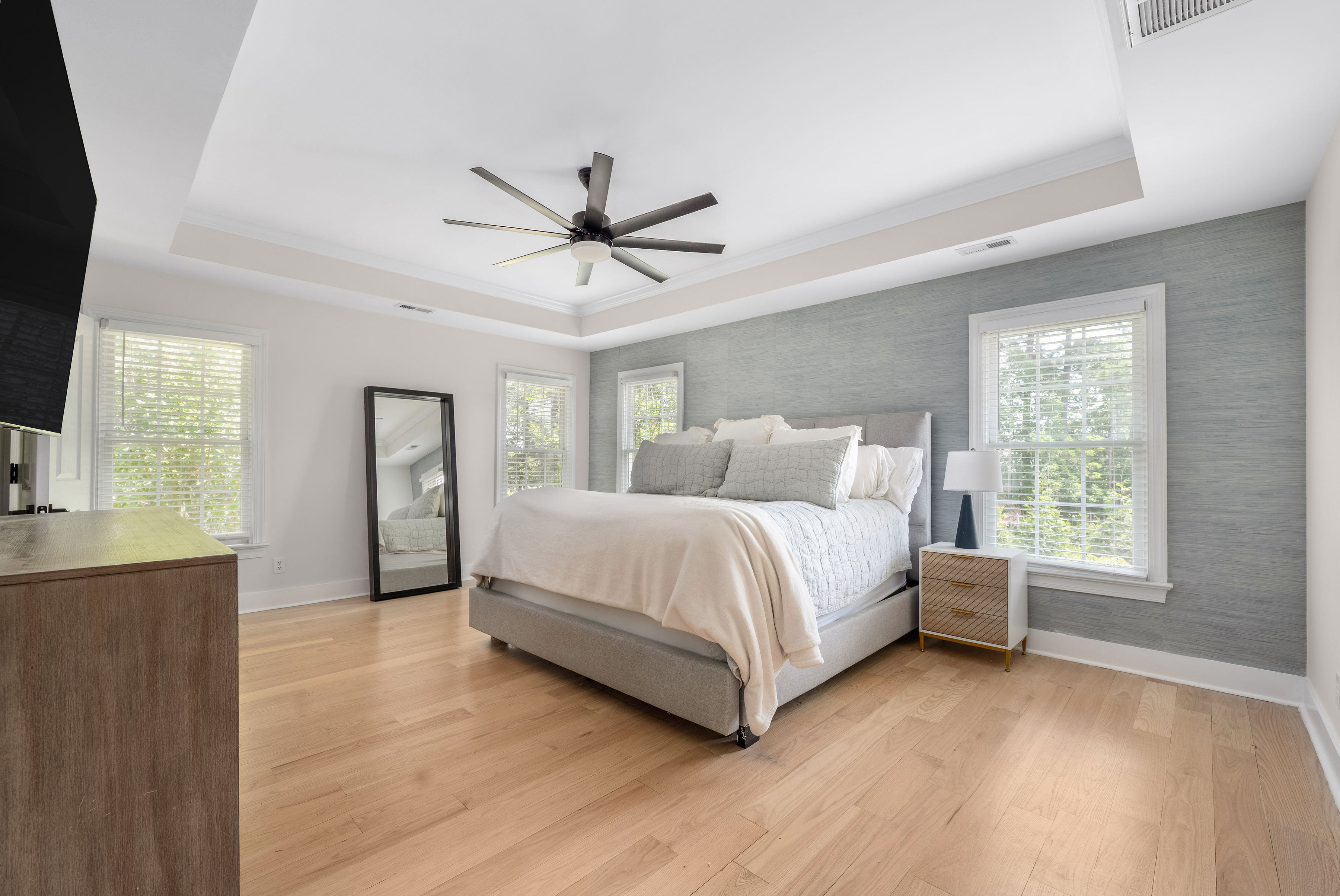 Spacious primary bedroom with elegant tray ceiling.