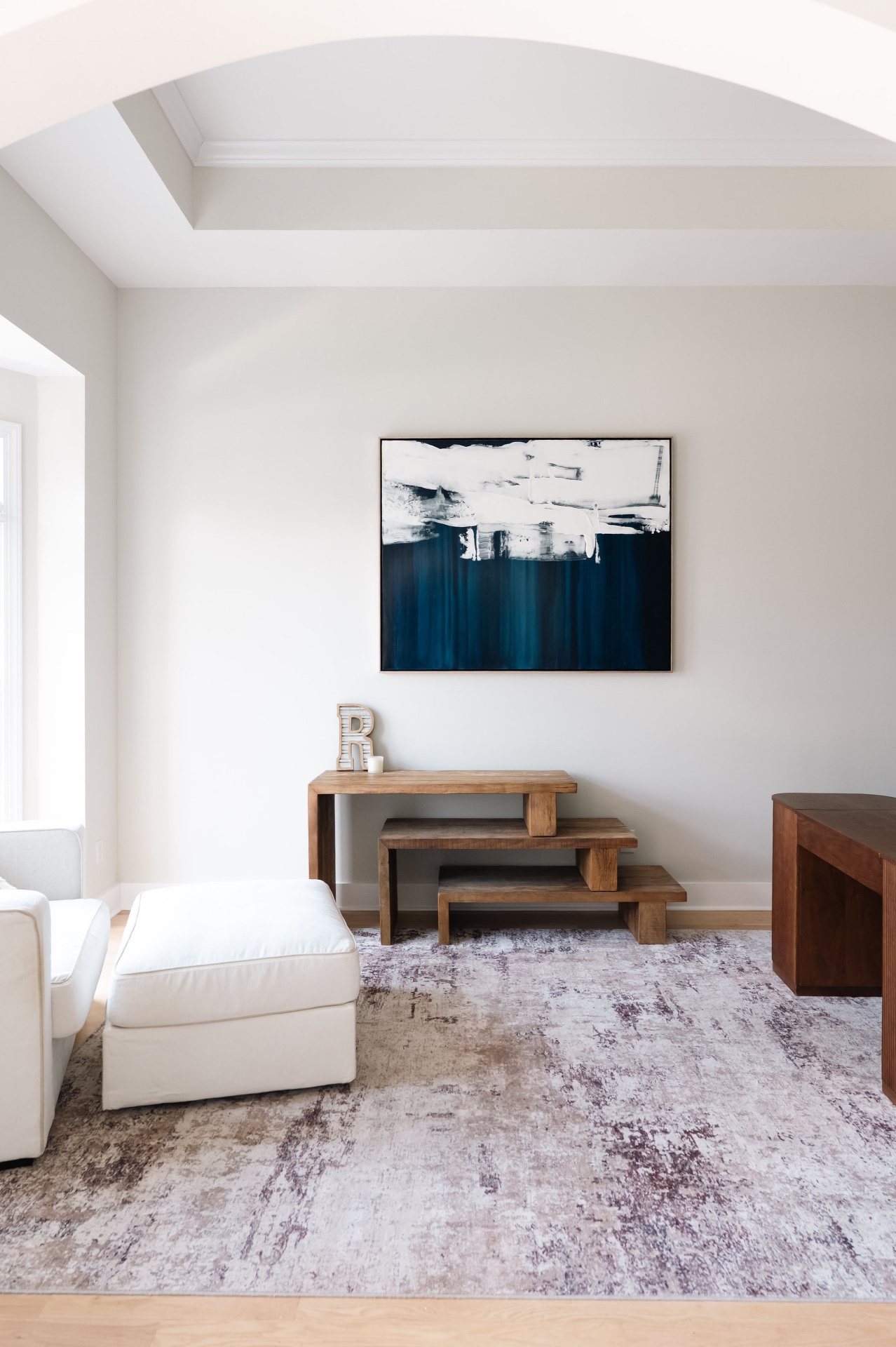 Primary suite sitting area with barrel-vaulted ceiling, abstract artwork, and cozy lounge seating.