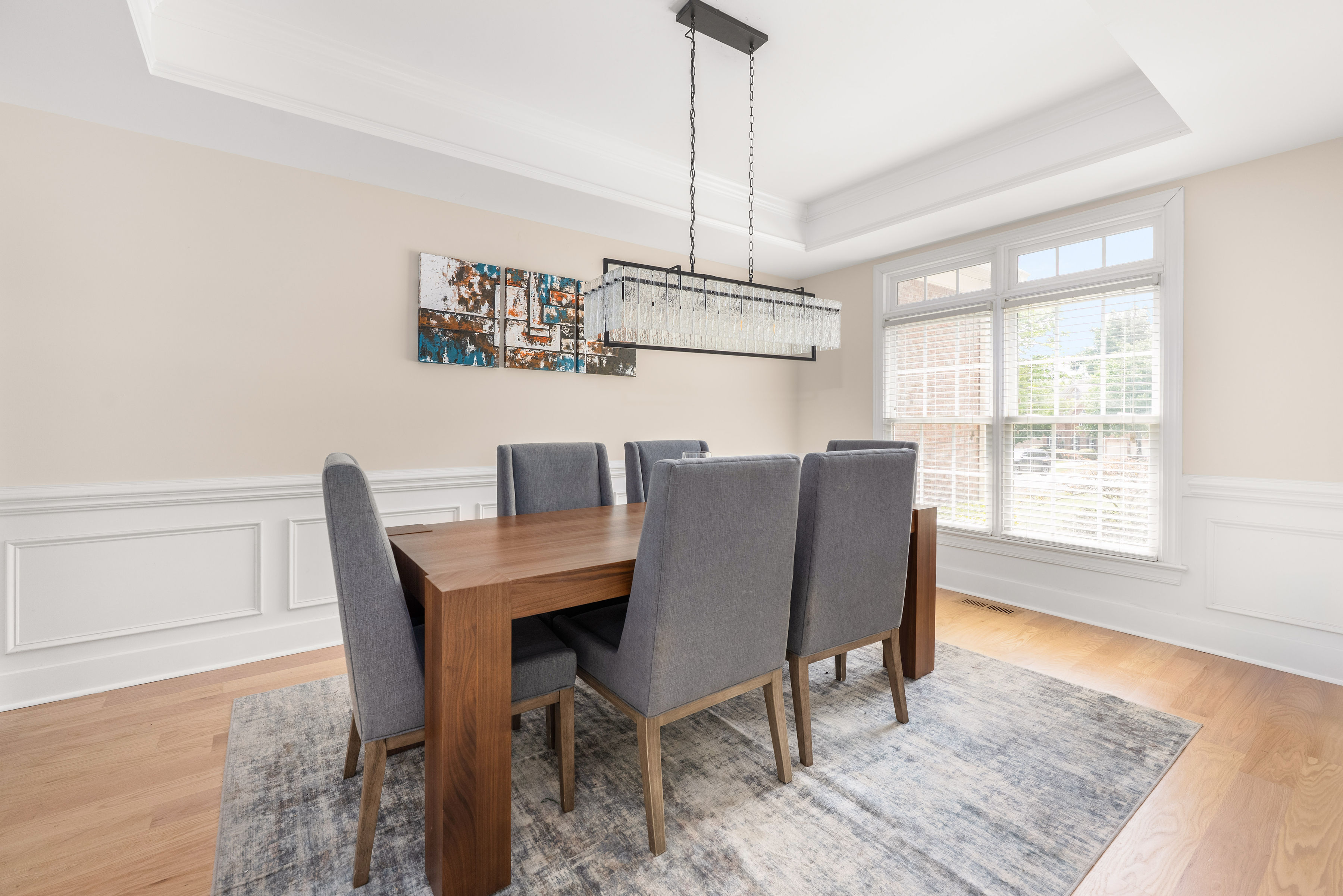 Dining room featuring a tray ceiling and elegant trim work.