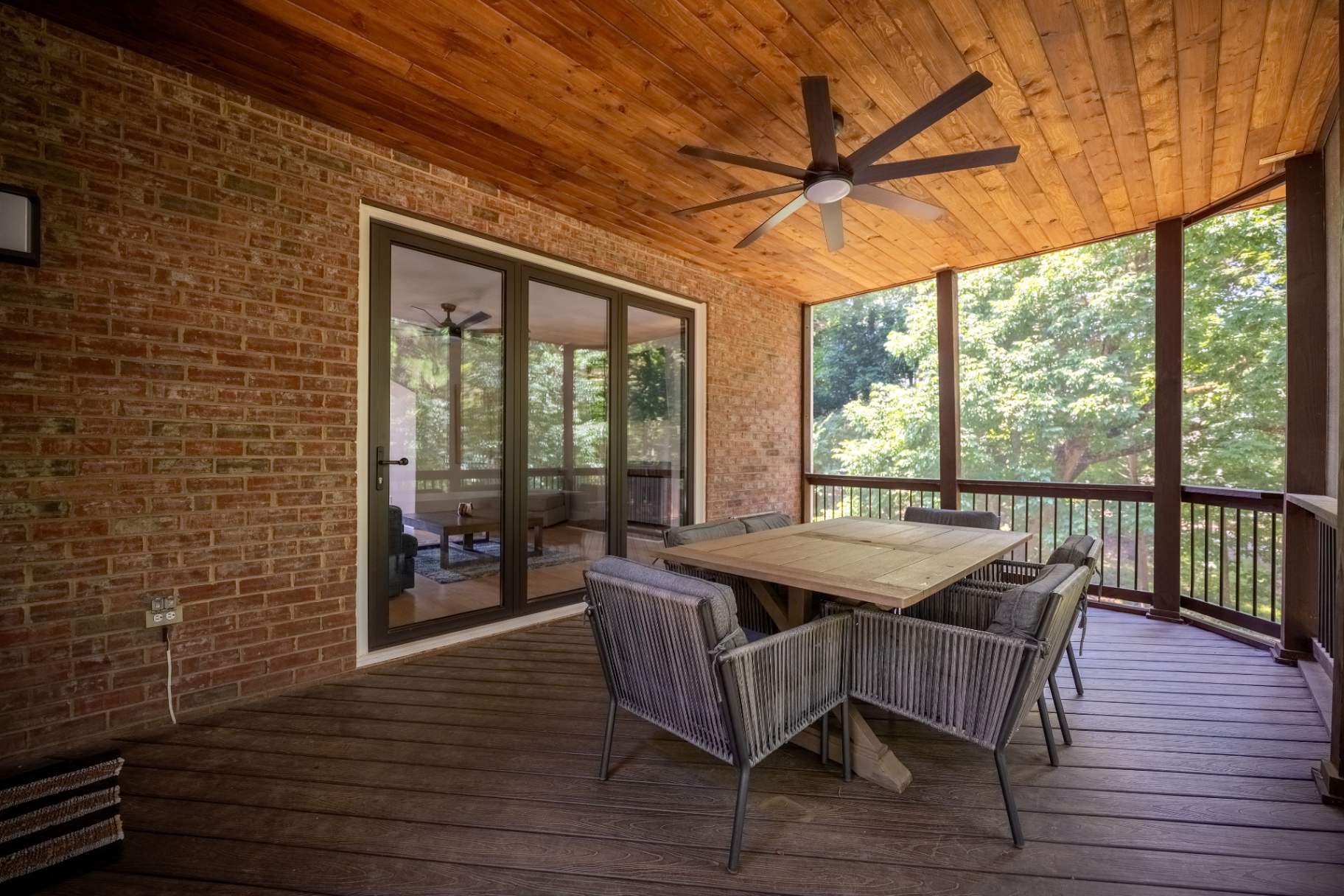 Covered screened porch with dining area and direct access to the living room.