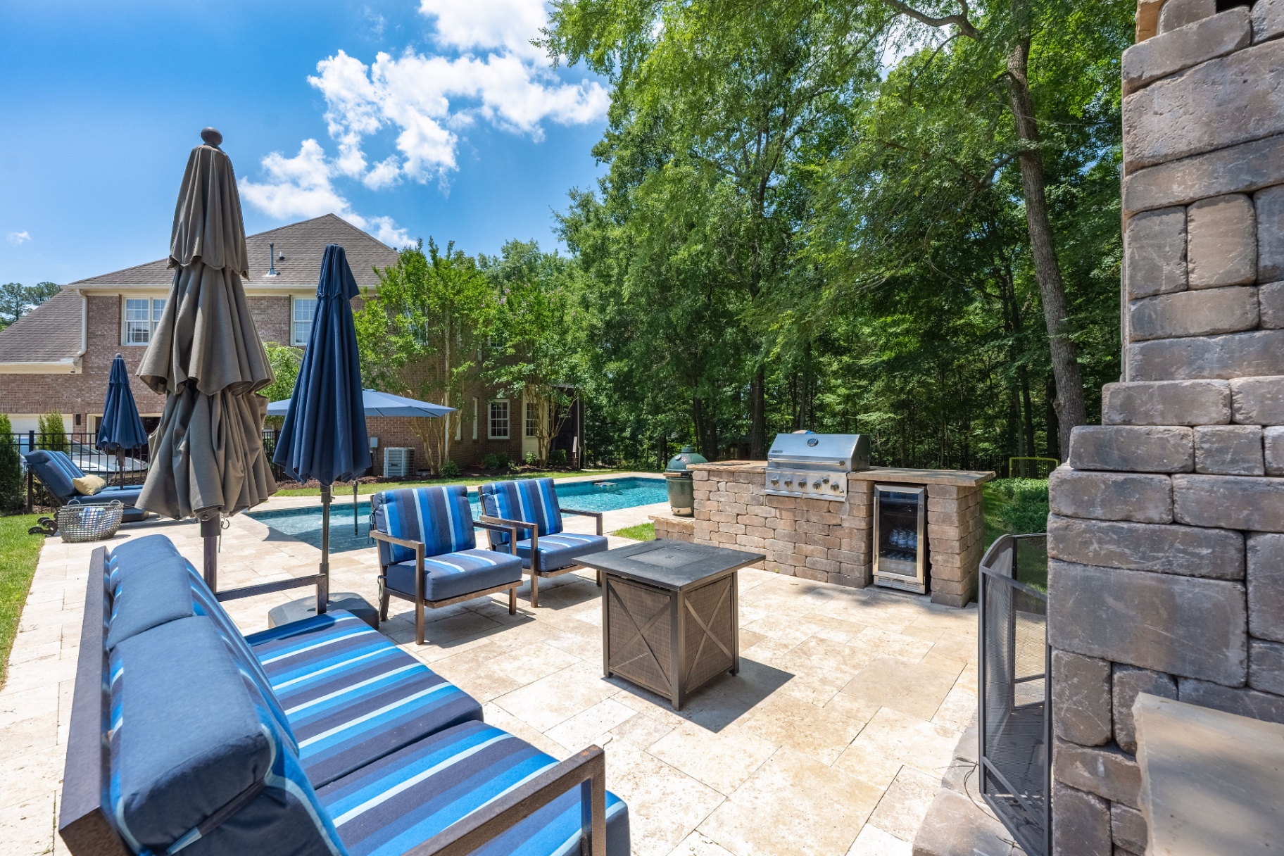 Outdoor living area connecting the terrace lounge, grill station, and pool.