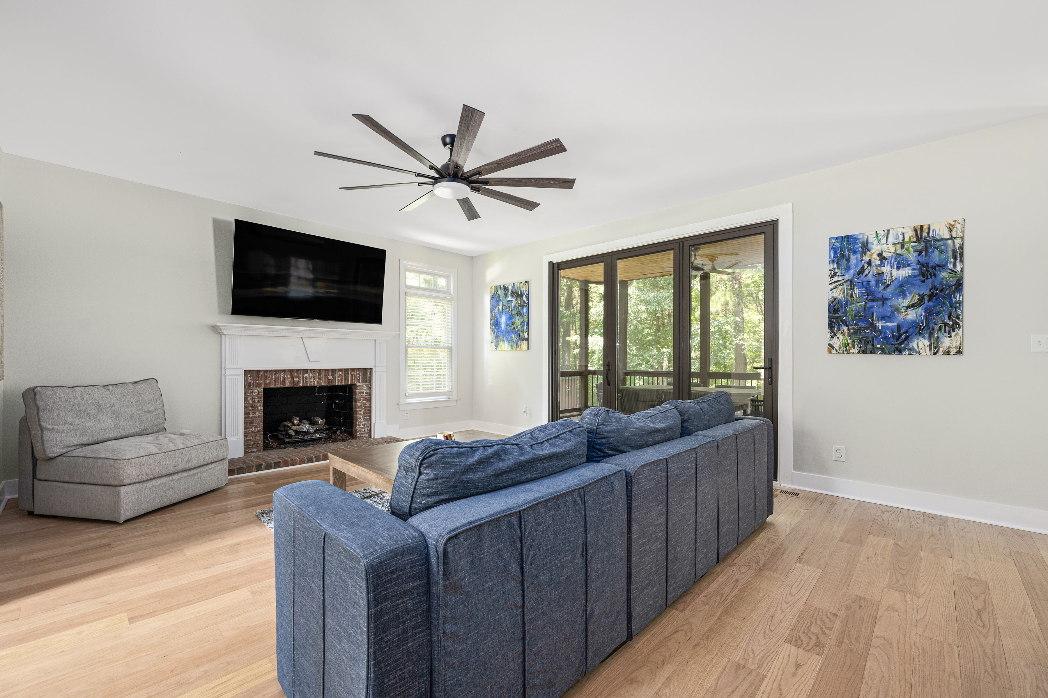 Living room with bifold doors opening to the kitchen, featuring a fireplace and an elegant archway from the entry