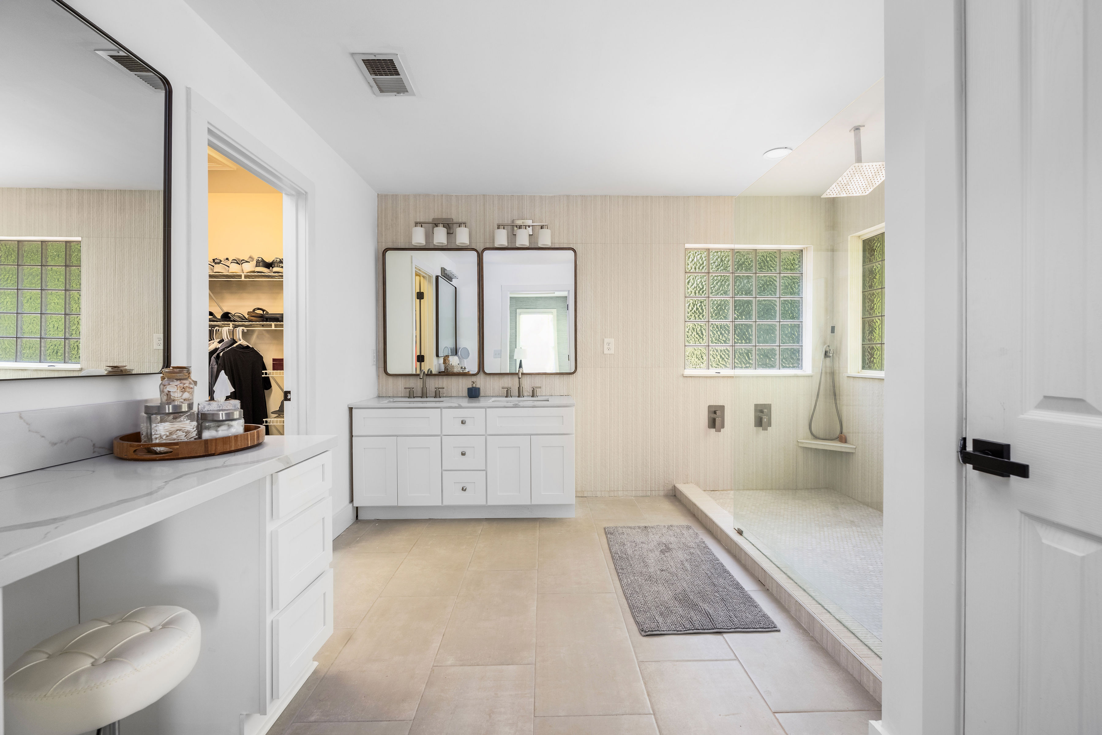 Primary bath featuring a double vanity, makeup vanity, and walk-in shower